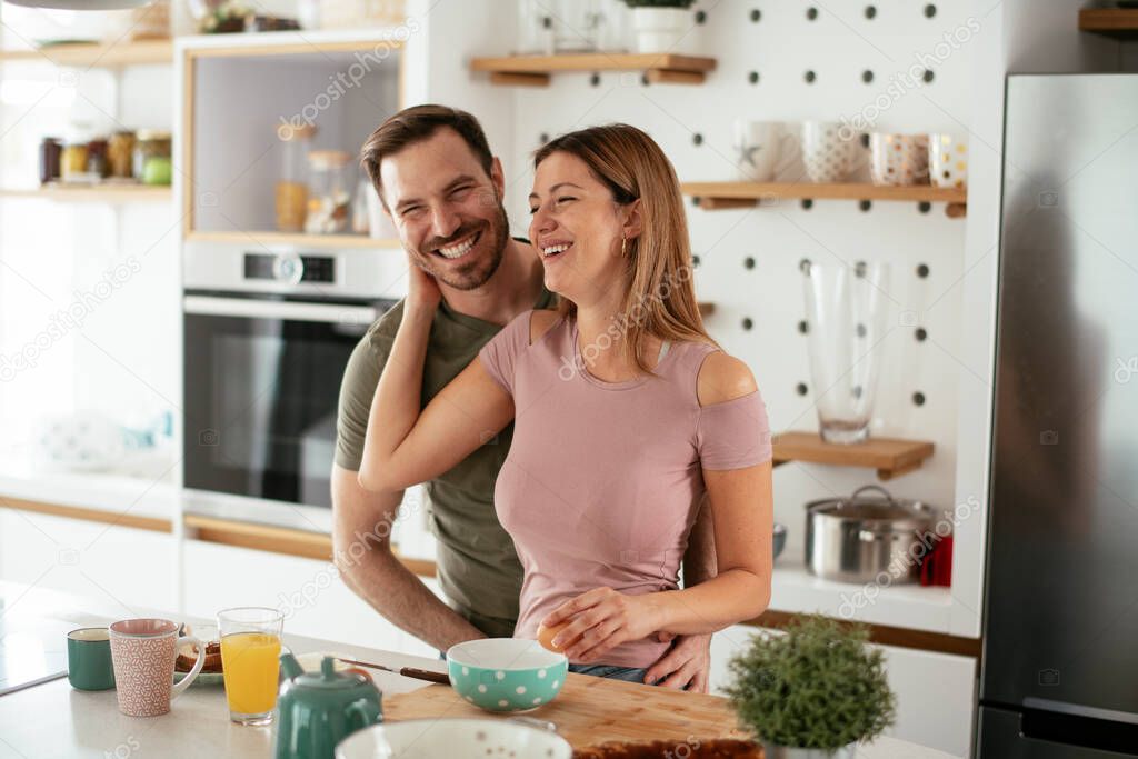 Young couple making sandwiches at home. Loving couple enjoying in the kitchen.
