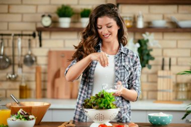 Güzel genç bayan mutfakta sebze salatası hazırlıyor..