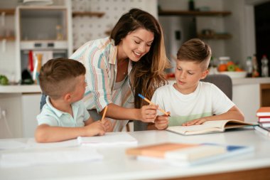Anne oğullarıyla ödev yapıyor.