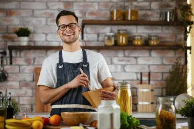 Mutfakta makarna hazırlayan yakışıklı adam. Lezzetli yemek pişiren adam..