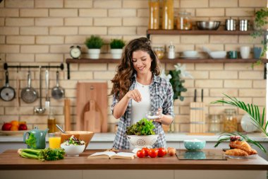 Güzel genç bayan mutfakta sebze salatası hazırlıyor..