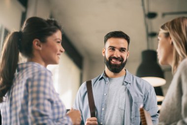 Modern açık uzay ofisinde sıradan iş adamlarından oluşan bir grup. İş kadınları ve işadamları yeni proje hakkında konuşuyor.