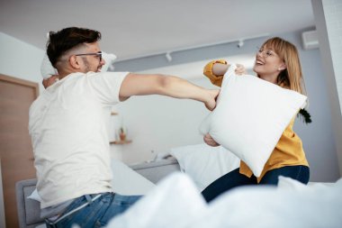 Mutlu çift evde yastıklarla kavga ediyor. 