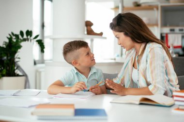 Anne oğluyla ödev yapıyor.