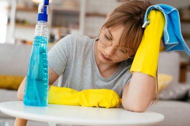 Evini temizleyen üzgün kadın. Evde yorgun bir kadın var..