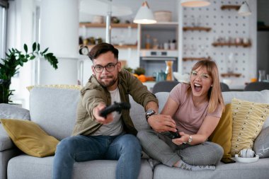 Çift evdeki kanepede oyun oynuyor.