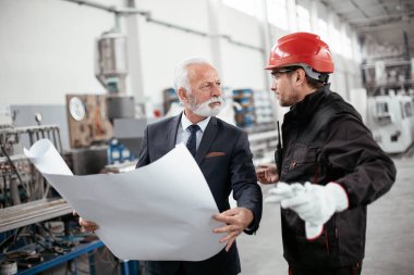İş arkadaşları birlikte çalışıyor. Fabrikada mimar ve işçi..