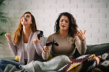 Evde video oyunu oynayan güzel genç kadınlar