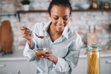 Güzel bir kadın yemek pişiriyor ve mutfakta eğleniyor. Kız mutfakta sağlıklı yemek pişiriyor..