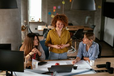 İş kadınları yeni bir proje üzerinde çalışıyor. İş arkadaşları ofiste iş tartışıyor.