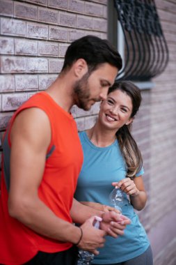 Atletik çift şehirde koştuktan sonra dinleniyor. Mutlu çift sabahları eğleniyor...