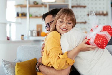 Adam kız arkadaşına hediyeyle sürpriz yapıyor. Genç adam kız arkadaşına hediye kutusu veriyor..