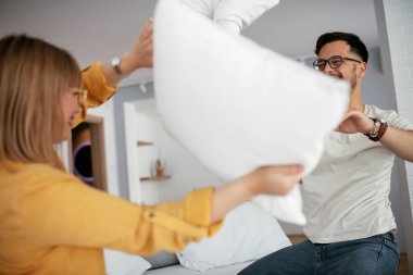 Mutlu çift evde yastıklarla kavga ediyor. 