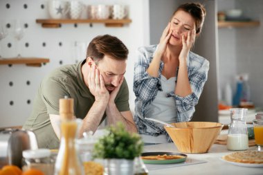 Çift evde birlikte yemek pişiriyor ve yemek hazırlıyor.