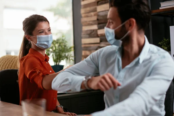 Businessman and businesswoman with medical mask in office. Colleagues working in office.