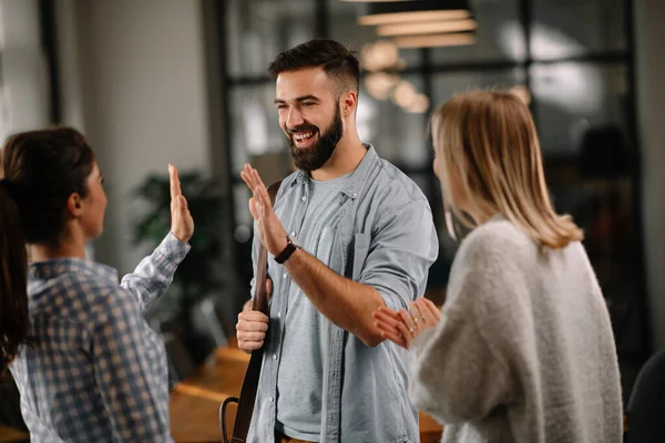 Group of casual business people talking in the modern open space office. Businesswomen and businessman talking about new project.