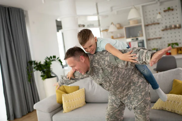 息子と家で遊んでいる兵士 居間で遊ぶ父と息子 — ストック写真