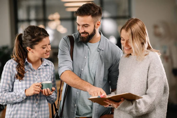 Modern açık uzay ofisinde sıradan iş adamlarından oluşan bir grup. İş kadınları ve işadamları yeni proje hakkında konuşuyor.