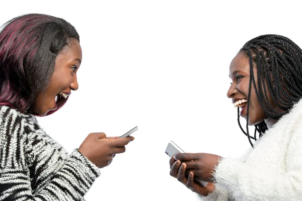 Carino africano giovanissima ragazze ridere con smart phones . — Foto Stock