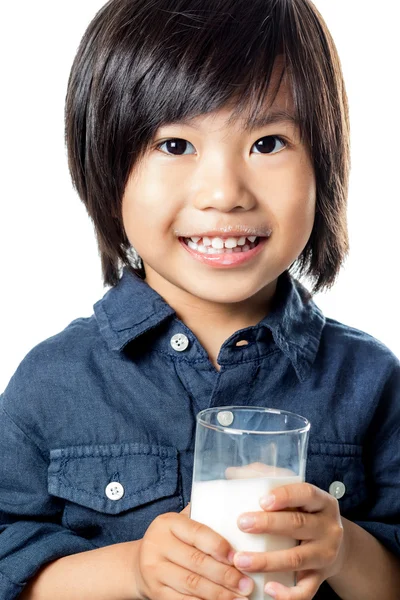 Cute azjatyckich chłopiec trzyma szklankę mleka. — Zdjęcie stockowe