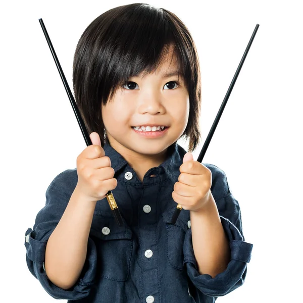 Маленький азиатский мальчик держит палочки для еды . — стоковое фото
