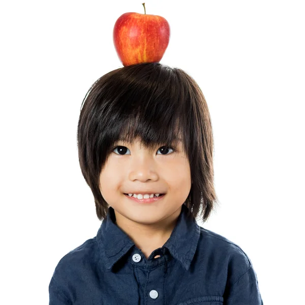 Pouco asiático menino com maçã na cabeça . — Fotografia de Stock