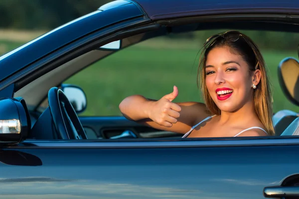 Woman doing thumb up sign in car. — Stock Photo, Image