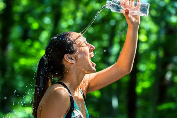 Girl pouring water on face after jog. — Stock Photo, Image