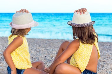 Kızlar denizde seyir şapka ile.