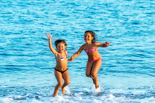 Meninas pulando em ondas . — Fotografia de Stock