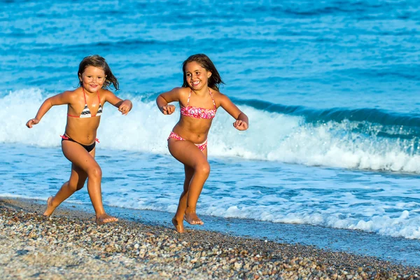 Enfants courant sur la plage de galets . — Photo