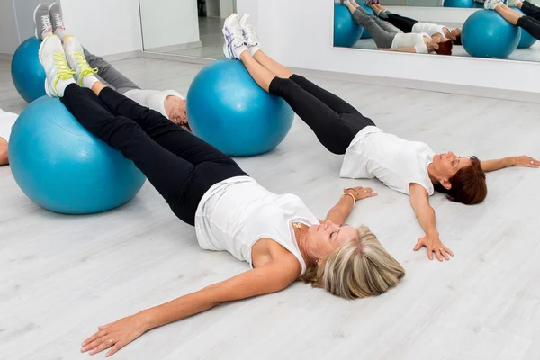 Mulheres de meia idade fazendo exercícios de pernas — Fotografia de Stock