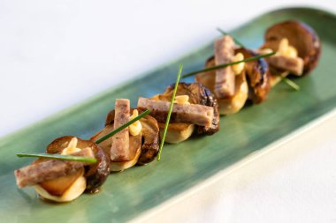 Makro, ızgara porcini mantarlı, gevrek domuz şeritli ve sarımsaklı mayonezli lokma..