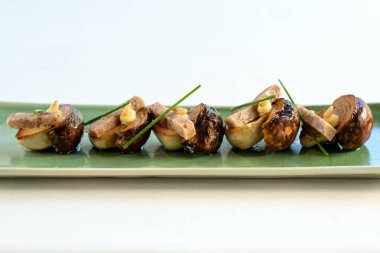 Izgara domuz eti ve sarımsaklı mayonezli mantarların önünü kapatın..