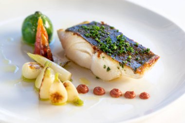 Makro iştah açıcı taze deniz levreği fileto bebek eko sebzelerle kızartılmış.