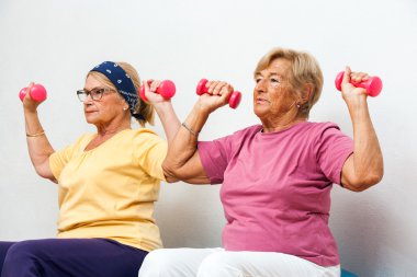 Senior female fitness girls working out with weights. clipart