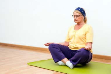 Üst düzey kadın spor salonunda meditasyon.