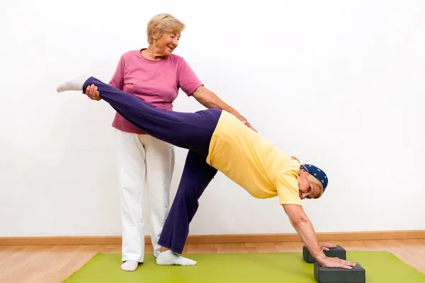 Seniorinnen helfen sich gegenseitig bei Dehnübungen. — Stockfoto