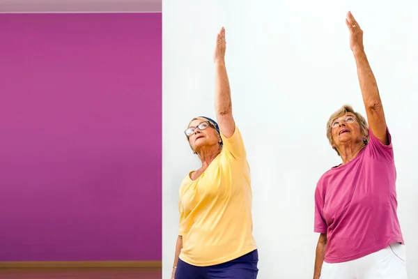 Äldre kvinnor stretching i gym. — Stockfoto