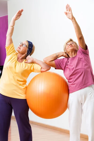 Mujeres mayores estirándose con pelota de gimnasio . — Foto de Stock