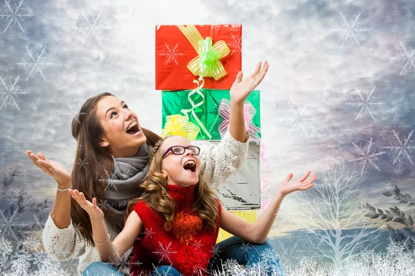 Meninas bonitos com presentes sob a neve . — Fotografia de Stock