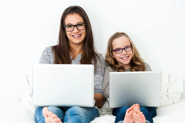 Jovens estudantes do sexo feminino relaxando com laptops . — Fotografia de Stock