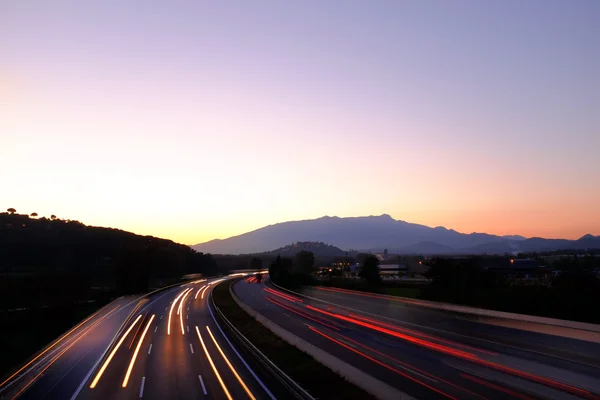 Solnedgång på buzy highway — Stockfoto