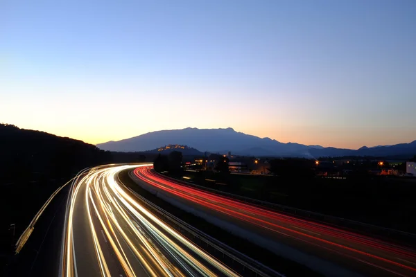 夕暮れ時に高速道路上のライトの光線. — ストック写真