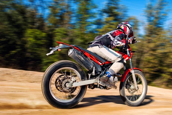 Teen boy riding Motocross bike on gravel road — Stock Photo, Image