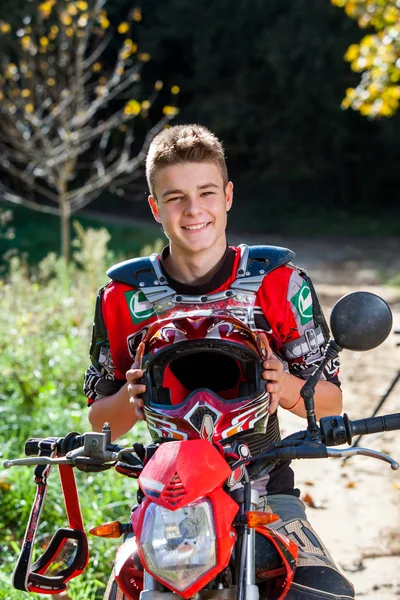 Knappe tiener jongen in motorcross outfit. — Stockfoto