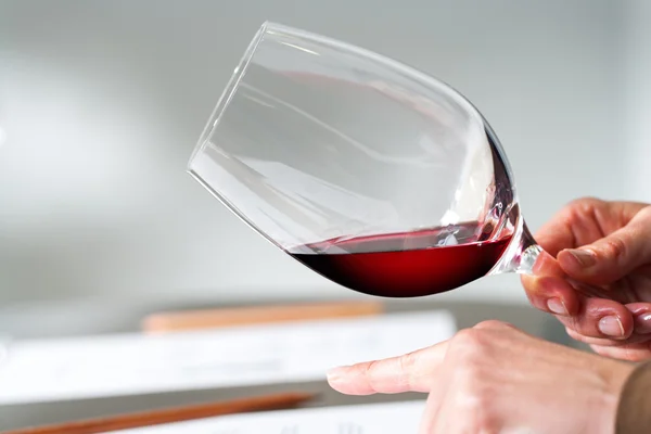 Mãos a testar a densidade do vinho na prova . — Fotografia de Stock