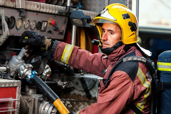 Bombeiro controlando a pressão da água no caminhão . — Fotografia de Stock