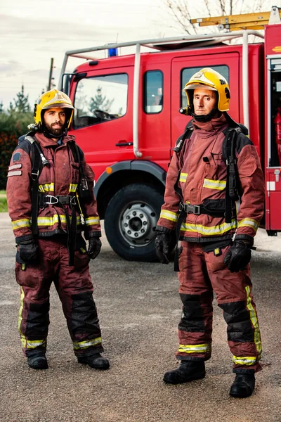 Firemen standing next to fire truck. — Stock Photo, Image