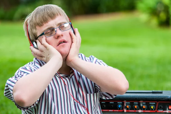 Gehandicapte jongen genieten van muziek op hoofd telefoons. — Stockfoto